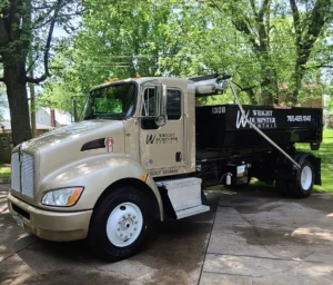 An image of a Wright dumpster rental truck with trees in the background