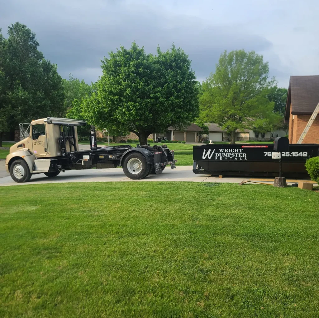 A semi-truck with a black dumpster attached to the back