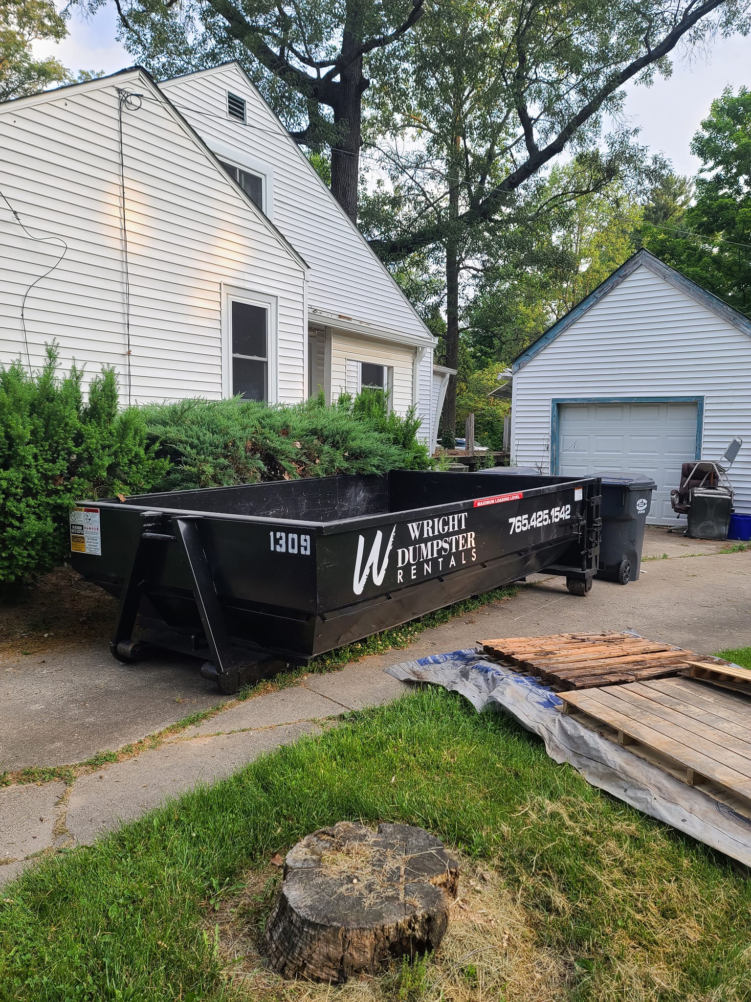 An image of black dumpster outside the house
