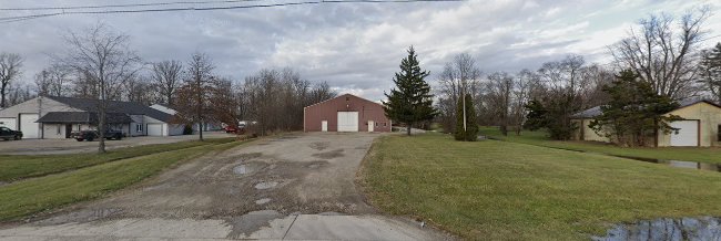 A landscape view of what appears to be a property with several building and a long driveway