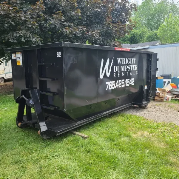 Wright Dumpster Rentals black 20-yard roll-off dumpster placed on a residential property